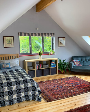 Interior of Dragon Nest studio apartment with comfortable double bed and boutique sofa